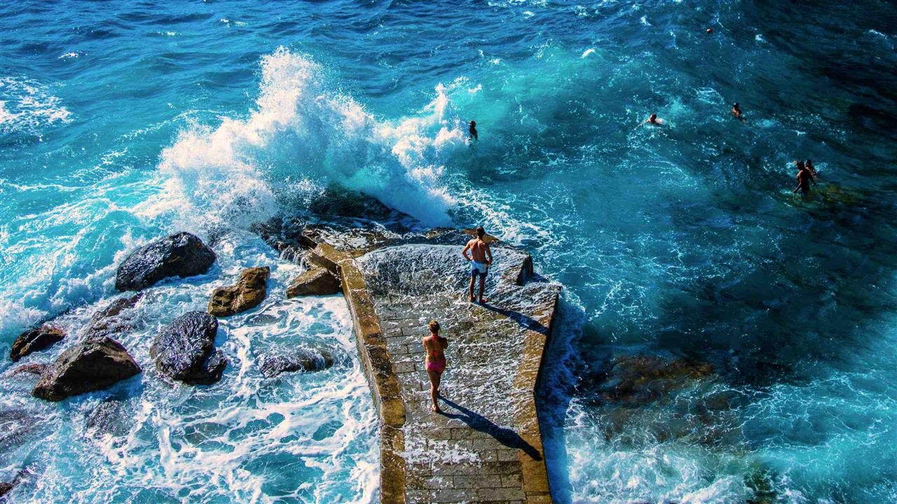 Paar an der Küste der Cinque Terre bei aufgewühltem Meer